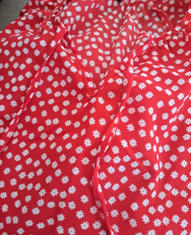 Blouse rouge à fleurs blanches